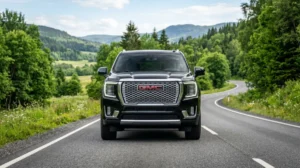 SUV GMC moderne et imposant circulant sur une route panoramique verdoyante, illustrant une marque de voiture en G.